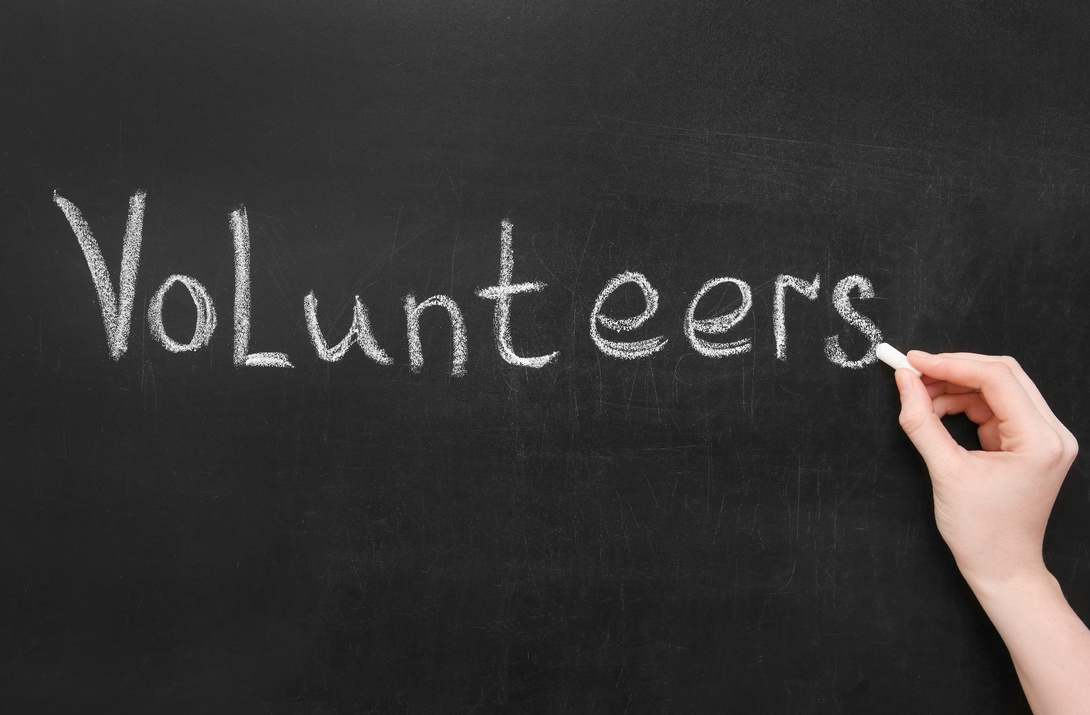 Woman Writing Word VOLUNTEERS on Chalkboard