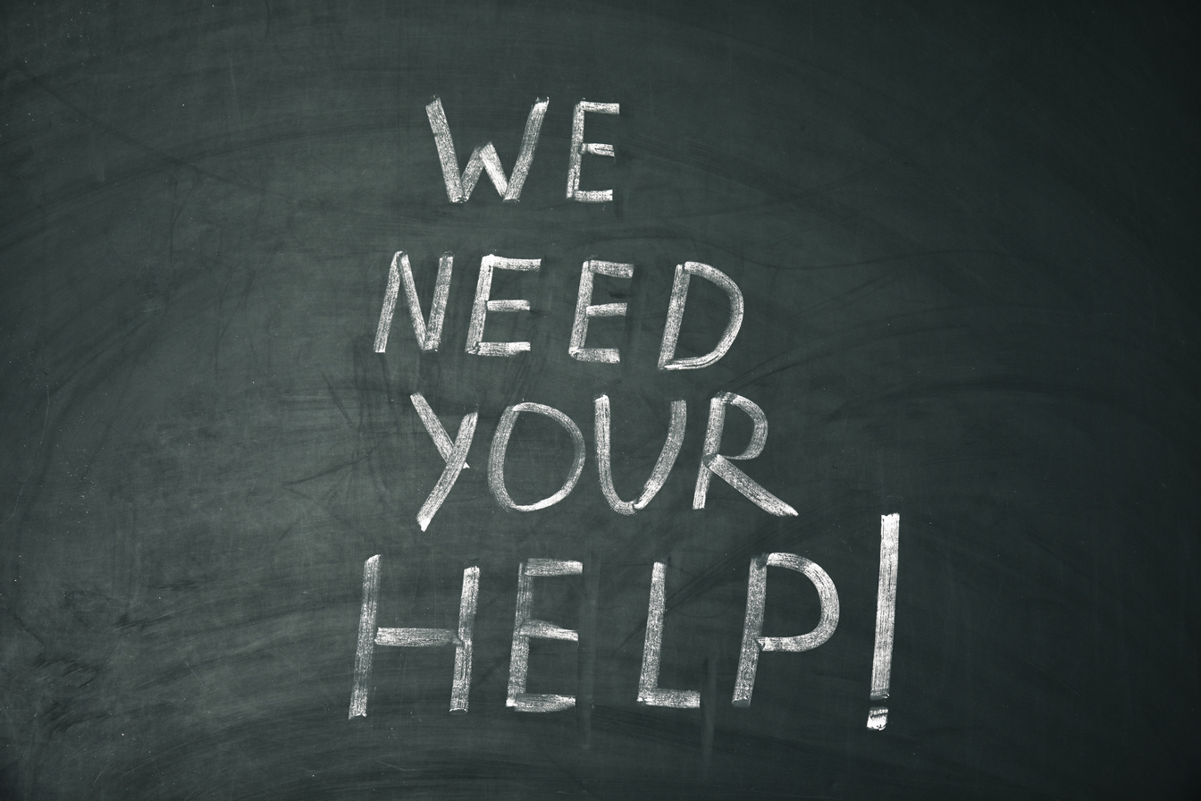 Phrase "We Need Your Help" Written on Chalkboard